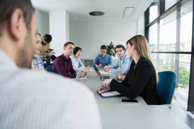 Bir grup iş adamı ofiste iş planlarını tartışıyor.