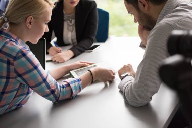 Bir grup iş adamı ofiste iş planlarını tartışıyor.