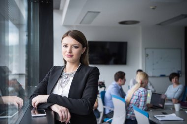 Ofisin içinde cep telefonu kullanan kadın yönetici.