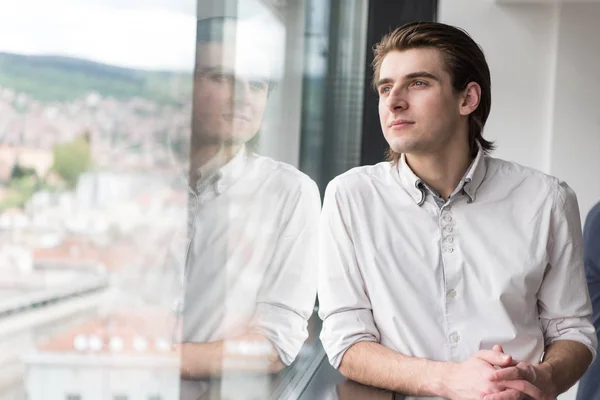 Νεαρός επιχειρηματίας στο γραφείο εκκίνησης από το παράθυρο — Φωτογραφία Αρχείου
