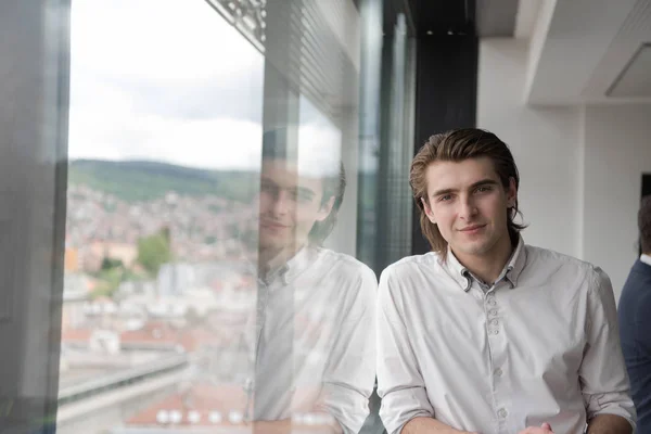 Joven hombre de negocios en la oficina de inicio por la ventana —  Fotos de Stock