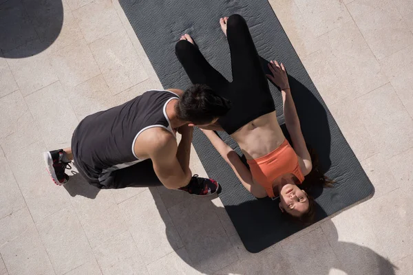 Frau mit Personal Trainer beim morgendlichen Yoga — Stockfoto