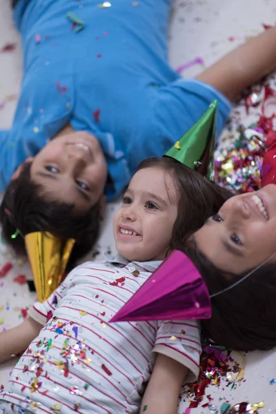 Kinderen confetti blazen terwijl liggend op de vloer — Stockfoto