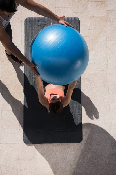 Mulher e personal trainer fazendo exercício com bola pilates — Fotografia de Stock