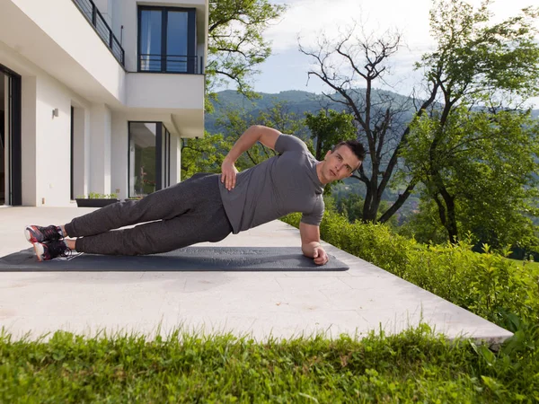 Hombre haciendo ejercicios de yoga por la mañana — Foto de Stock