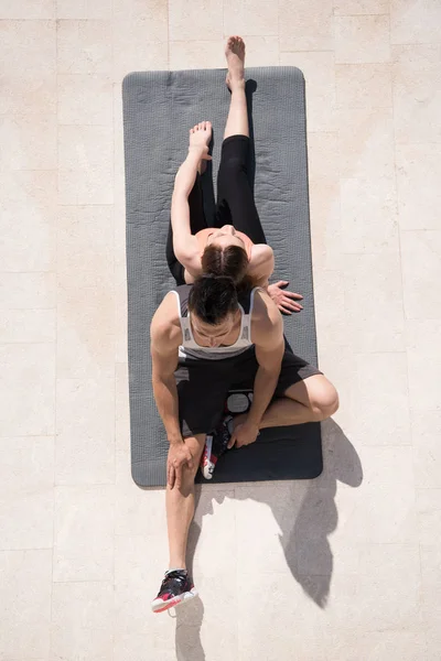 Femme avec entraîneur personnel faisant du yoga matinal — Photo