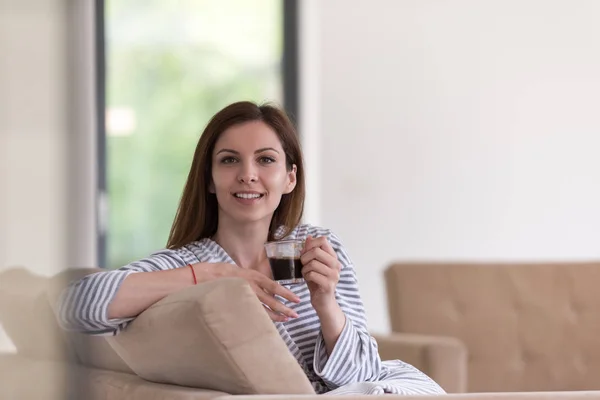 Ung kvinna i en morgonrock som du njuter av morgonkaffet — Stockfoto