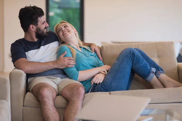 Jovem casal feliz relaxa na sala de estar — Fotografia de Stock