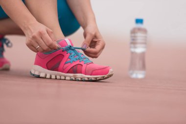 genç kadın üzerinde spor ayakkabı ayakkabı bağcığı bağlama