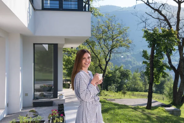 Vrouw in een badjas genieten van koffie in de ochtend — Stockfoto