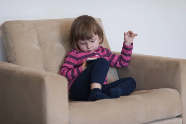 Kleines Mädchen spielt Spiele auf dem Smartphone — Stockfoto