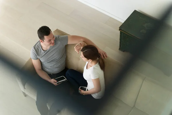 Пара розслабляється вдома з планшетними комп'ютерами — стокове фото