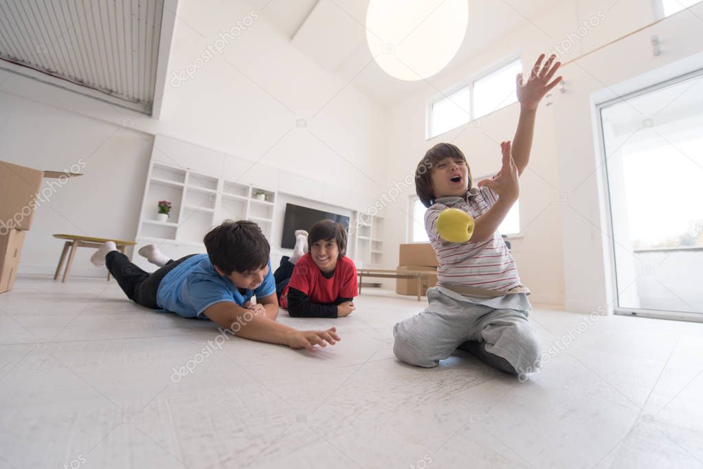 boys having fun with an apple on the floor