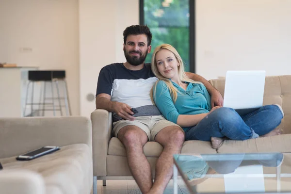 Mladý šťastný pár uvolňuje v obývacím pokoji — Stock fotografie