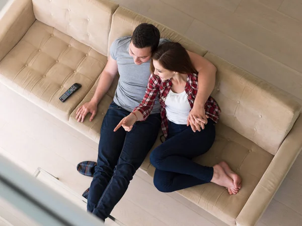Unga par i soffan tittar på TV — Stockfoto