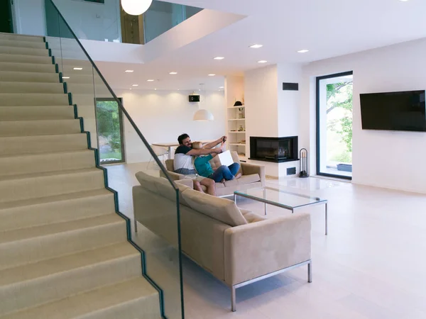 Young happy couple relaxes in the living room — Stock Photo, Image