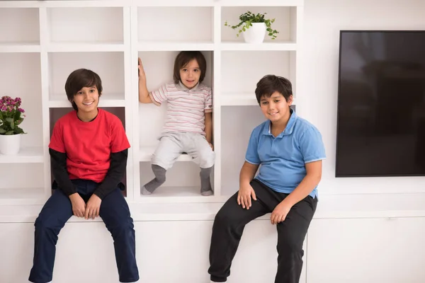 Giovani ragazzi in posa su uno scaffale — Foto Stock