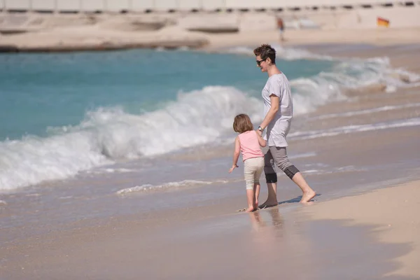 Mutter und Tochter rennen am Strand — Stockfoto