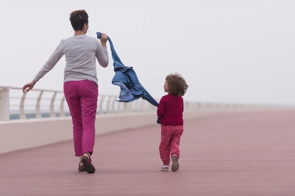 Mother and cute little girl on the promenade by the sea — Stock Photo, Image