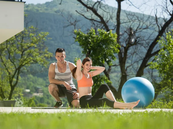 Vrouw met personal trainer ochtend yoga doen — Stockfoto