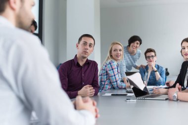Bir grup iş adamı ofiste iş planlarını tartışıyor.