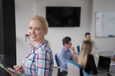 İş kadını pencere kenarındaki kurumsal ofiste dijital tablet kullanıyor