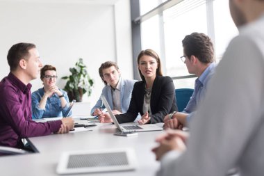 Bir grup iş adamı ofiste iş planlarını tartışıyor.