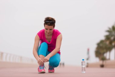 genç kadın üzerinde spor ayakkabı ayakkabı bağcığı bağlama