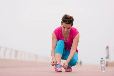 genç kadın üzerinde spor ayakkabı ayakkabı bağcığı bağlama