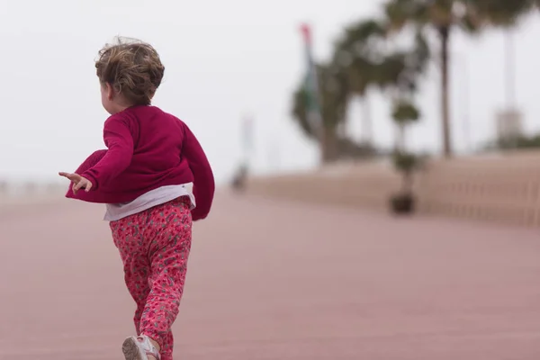 Cute little girl on the promenade by the sea — Stock Photo, Image