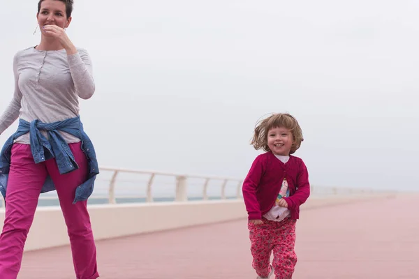 Mutter und süßes kleines Mädchen auf der Promenade am Meer — Stockfoto