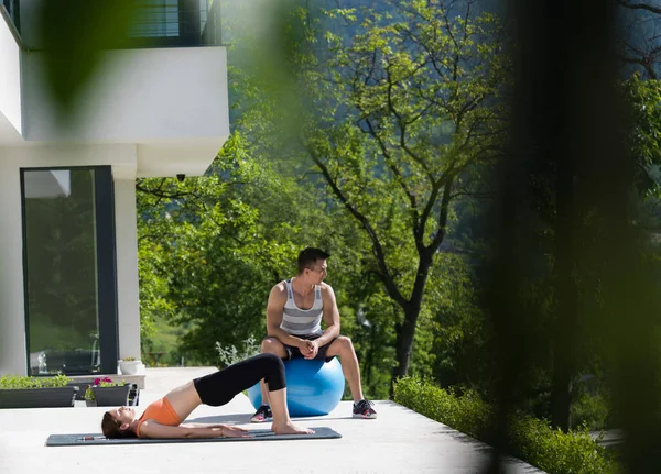 Femme et entraîneur personnel faisant de l'exercice avec ballon pilates — Photo