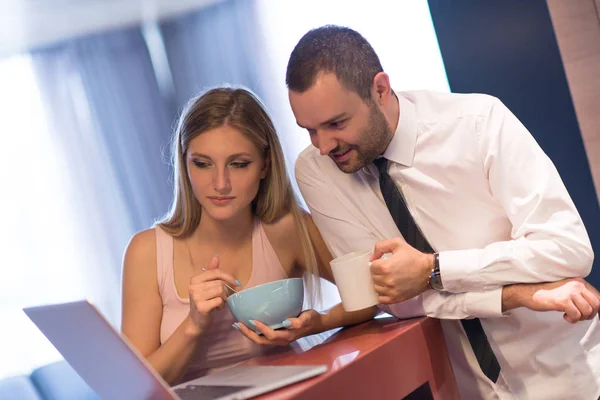 Ett ungt par förbereder sig för ett jobb och använder en bärbar dator — Stockfoto