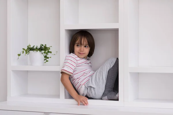 Giovane ragazzo posa su uno scaffale — Foto Stock