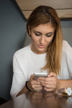 Cep telefonu kullanan genç kadın.