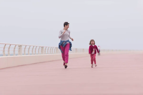 Mother and cute little girl on the promenade by the sea — Stock Photo, Image
