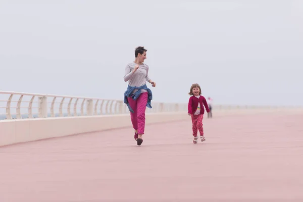 Mutter und süßes kleines Mädchen auf der Promenade am Meer — Stockfoto