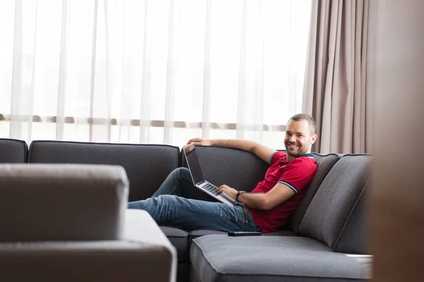 Hombre usando el portátil en la sala de estar — Foto de Stock