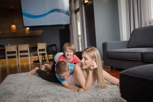 Junge Mutter verbringt Zeit mit Kindern auf dem Fußboden — Stockfoto