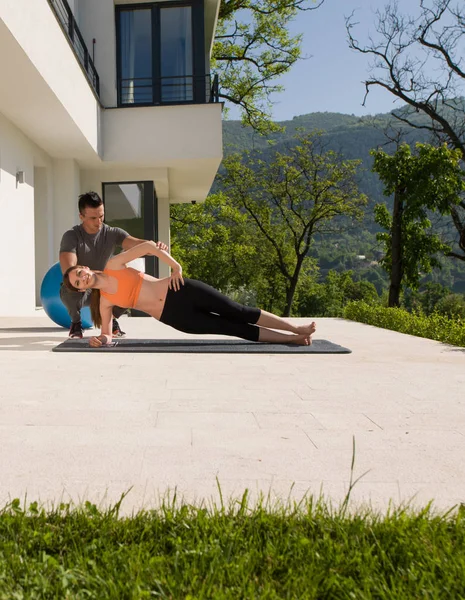Mulher com personal trainer fazendo ioga manhã — Fotografia de Stock