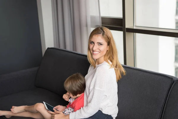 Mother and her cute little daughter are using a tablet — Stock Photo, Image