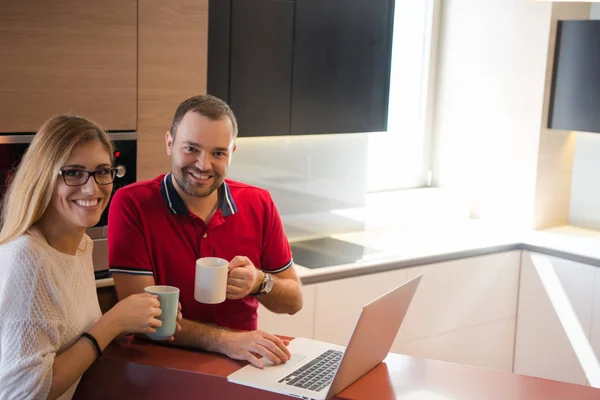 Casal beber café e usando laptop em casa — Fotografia de Stock