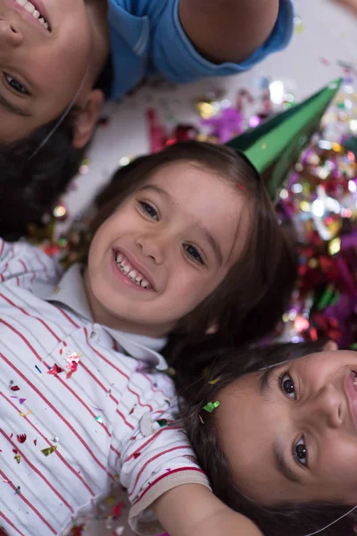 Crianças Felizes Comemorando Festa Com Soprando Confete Enquanto Deitado Chão — Fotografia de Stock