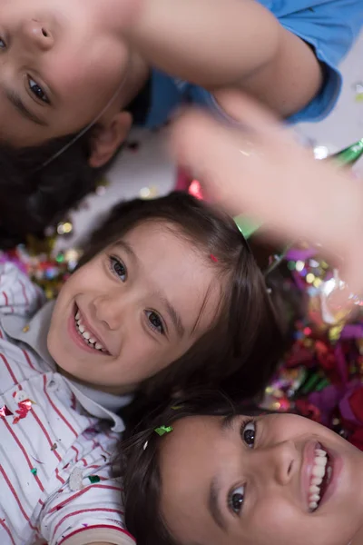 Niños Felices Celebrando Fiesta Con Soplado Confeti Mientras Yacen Suelo — Foto de Stock