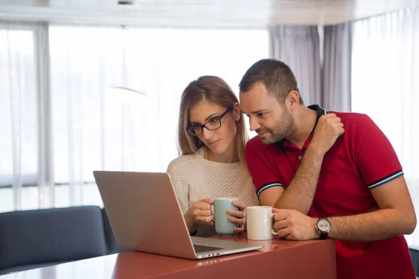 Par dricka kaffe och använder bärbar dator hemma — Stockfoto