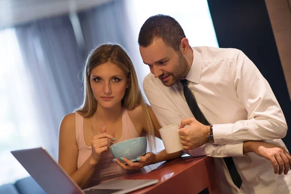 Ett ungt par förbereder sig för ett jobb och använder en bärbar dator — Stockfoto