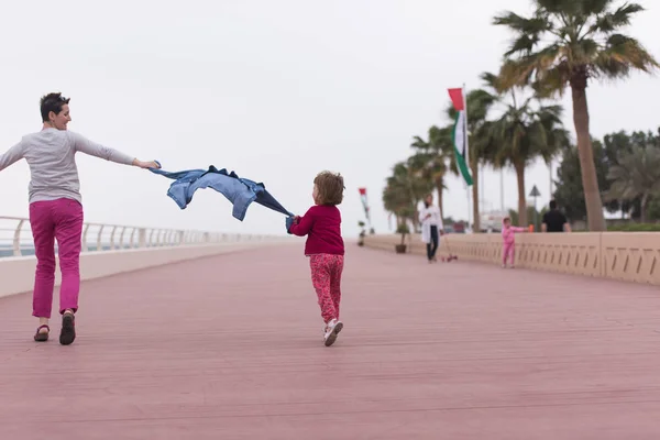 Mutter und süßes kleines Mädchen auf der Promenade am Meer — Stockfoto