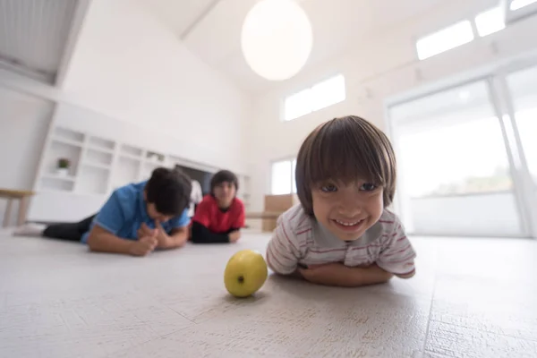 Αγόρια διασκεδάζοντας με ένα μήλο στο πάτωμα — Φωτογραφία Αρχείου