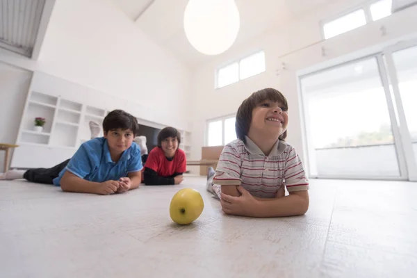 Chłopcy świetnie się bawią z jabłkiem na podłodze — Zdjęcie stockowe