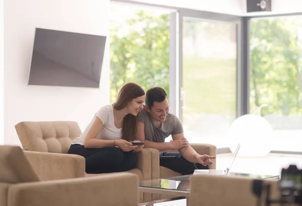 Pareja relajante en casa con tabletas y computadoras portátiles — Foto de Stock